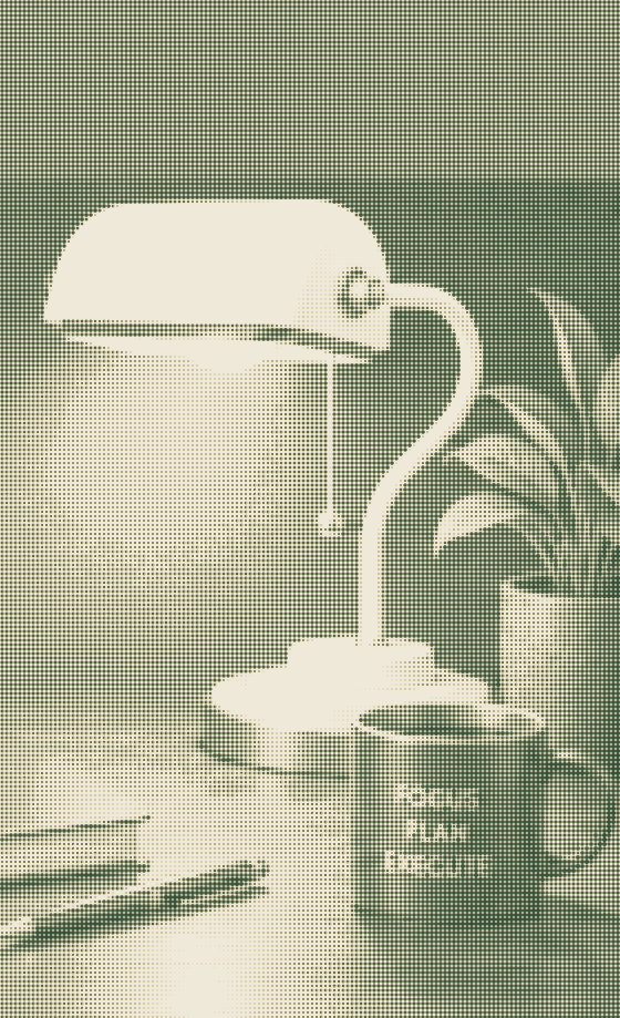 A banker's lamp lit over a desk